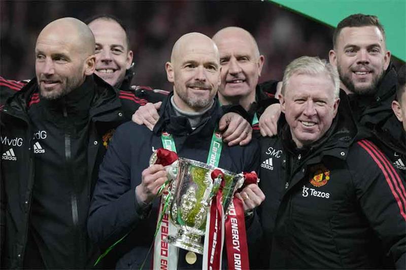 L'entraîneur principal de Manchester United, Erik ten Hag, au centre, et les membres de l'équipe posent avec le trophée après la Coupe de la Ligue.